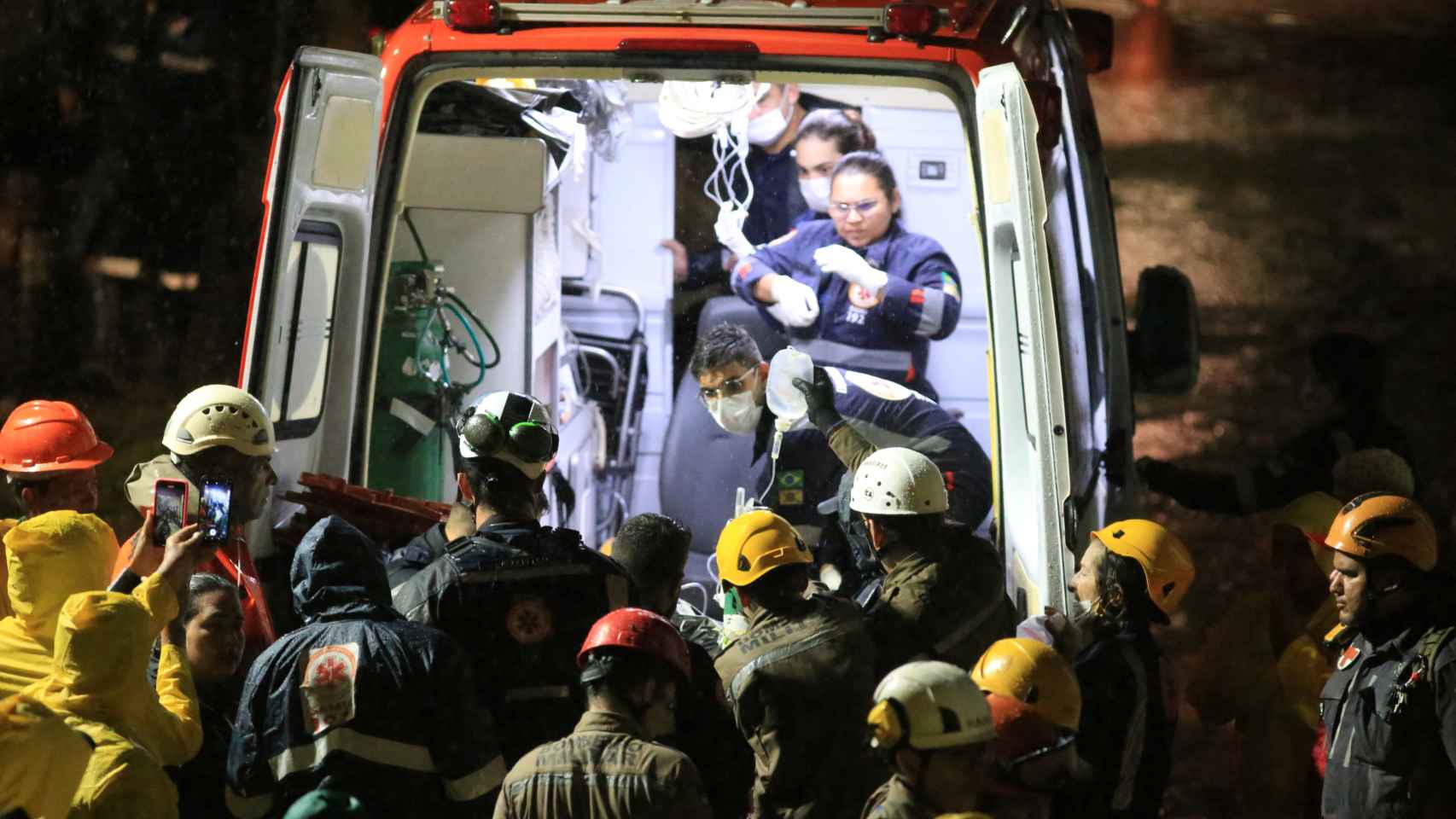 Equipas de salvamento transportam uma pessoa ferida encontrada nos escombros após o desabamento de um edifício no estado do Recife, Pernambuco, Brasil.